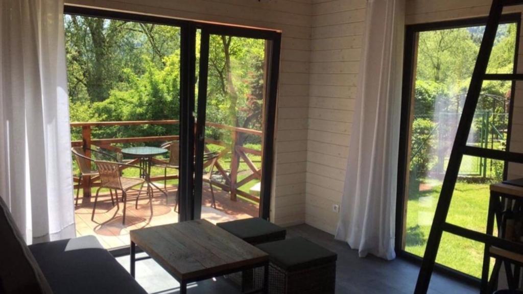 a screened in porch with a table and chairs and a patio at Mała Ostoja in Polanica-Zdrój