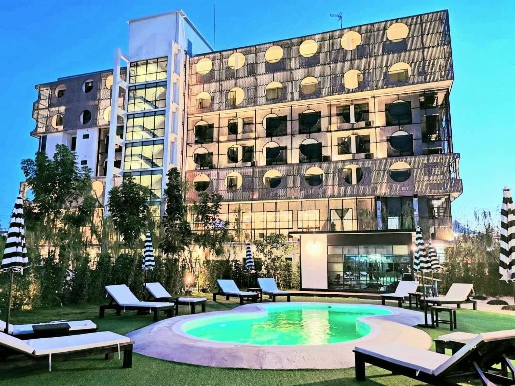 un hôtel avec une piscine en face d'un bâtiment dans l'établissement Hotel Fuse Rayong, à Rayong
