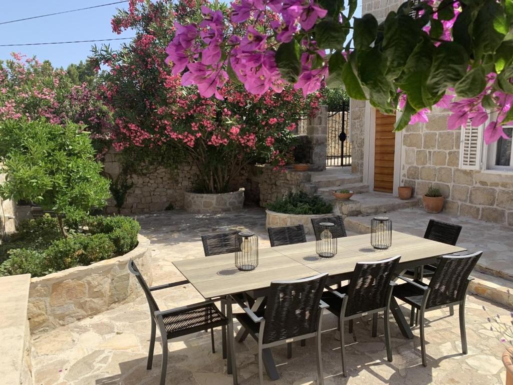 a table and chairs in a patio with purple flowers at Villa By The Sea Near Dubrovnik in Cavtat