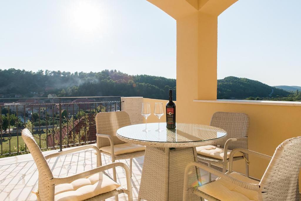 - une table avec une bouteille de vin sur le balcon dans l'établissement Casa Scardona, à Skradin