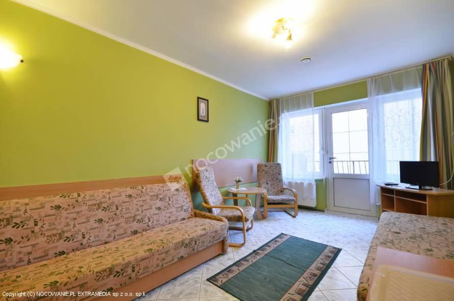 a living room with a couch and a table at Pokoje ANNA in Rewal