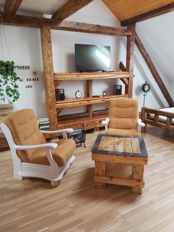 a living room with two chairs and a tv at Apartmán Sarah Noemi, 100 m SKIBUS JASNA in Liptovský Mikuláš