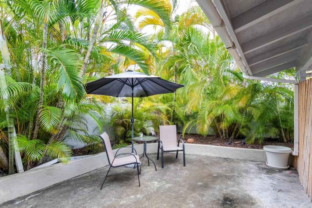 a patio with a table and two chairs and an umbrella at Kalama Room in Kailua