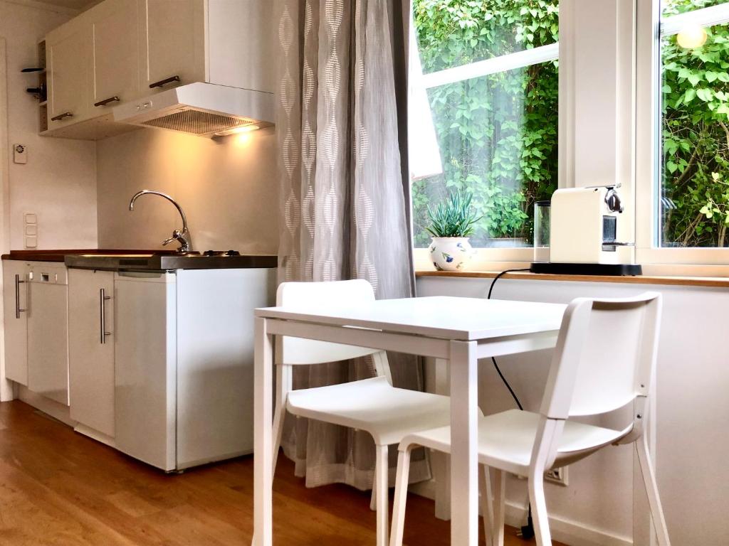 una cocina con una mesa y sillas blancas y una ventana en Lovely studio in the citycenter of Sigtuna en Sigtuna