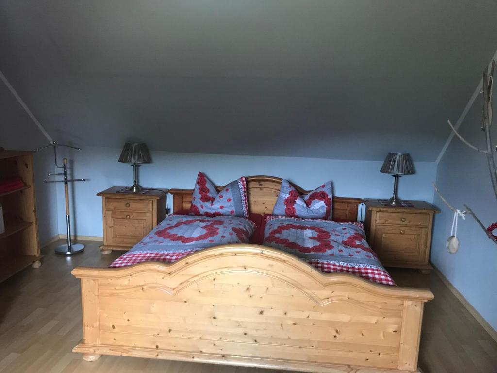 a bedroom with a wooden bed with two pillows at Ferienwohnung am Hochrhöner 
