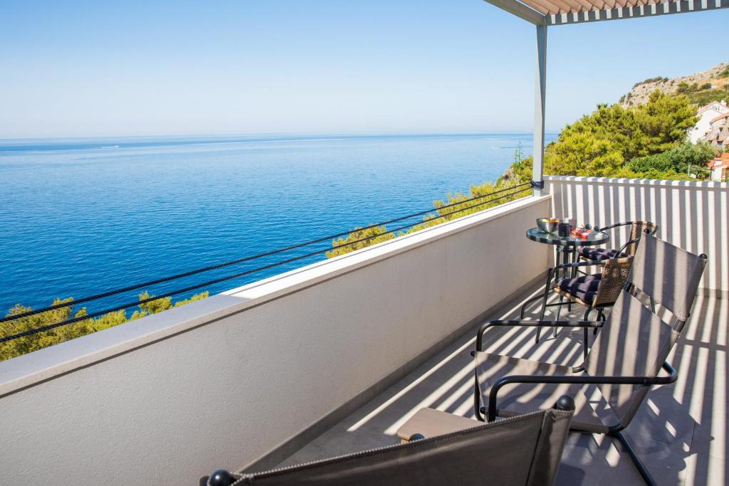 2 stoelen op een balkon met uitzicht op het water bij Studio 87 in Dubrovnik