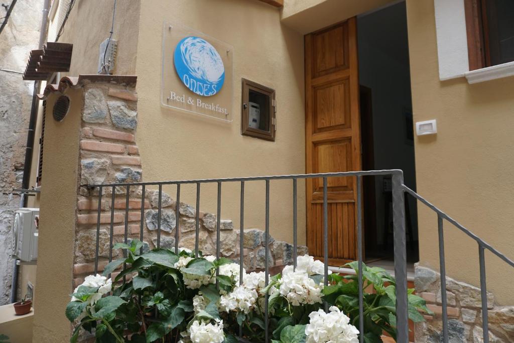znak na ścianie budynku z kwiatami w obiekcie Casa Vacanze B&B Ondes w mieście Camerota
