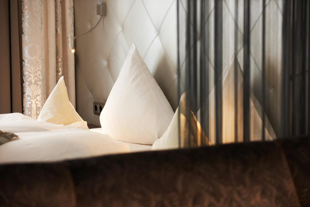 a bedroom with a bed with white sheets and pillows at Hotel Brigitte in Ischgl