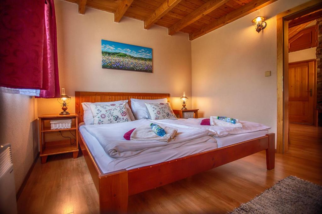 una camera da letto con letto, lenzuola e cuscini bianchi di Chatka Aqua440 Tatralandia a Liptovský Mikuláš