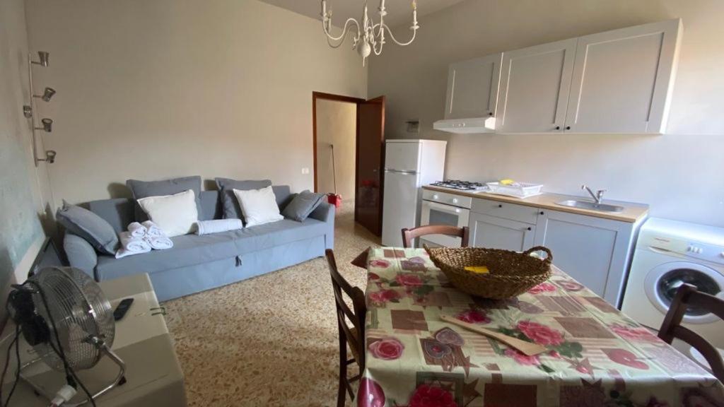 una cucina e un soggiorno con divano e tavolo di Appartamenti vacanze Marina di bibbona a Marina di Bibbona