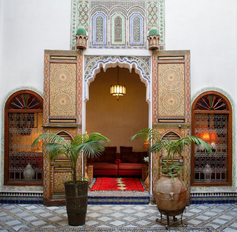 a living room with a red couch in a building at Riad Idrissy in Fez