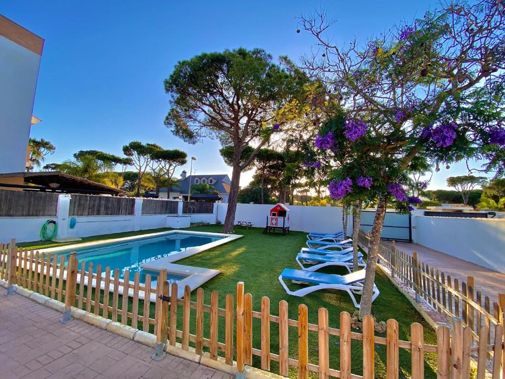 - une piscine avec des chaises longues dans la cour dans l'établissement Parisito beach, à Chiclana de la Frontera