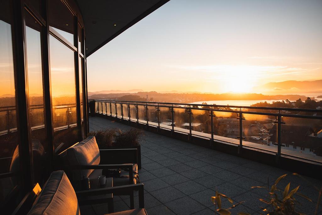 uma vista para o pôr-do-sol a partir da varanda de um edifício em Stord Hotel em Stord