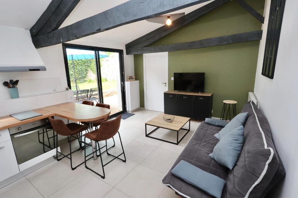 een woonkamer met een bank en een tafel bij L'atelier et sa terrasse in Pontivy