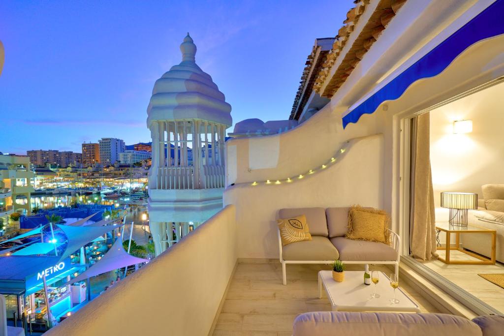 - un balcon avec vue sur la ville la nuit dans l'établissement weforyou Ola Puerto Marina Apartment, à Benalmádena