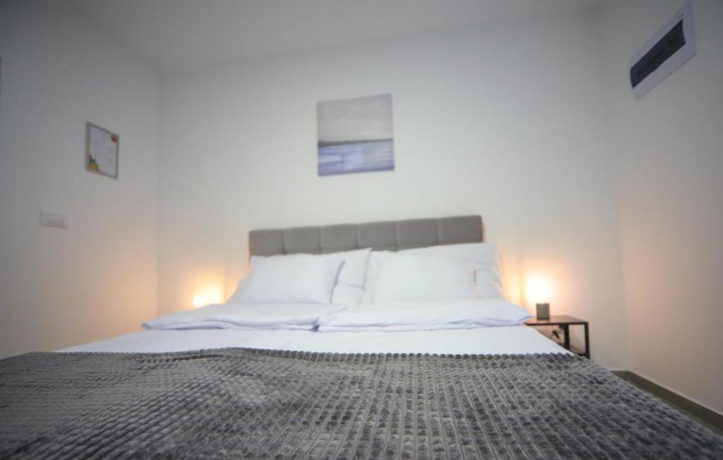 - une chambre avec un grand lit et des draps blancs dans l'établissement Code Srebrno Jezero, à Veliko Gradište