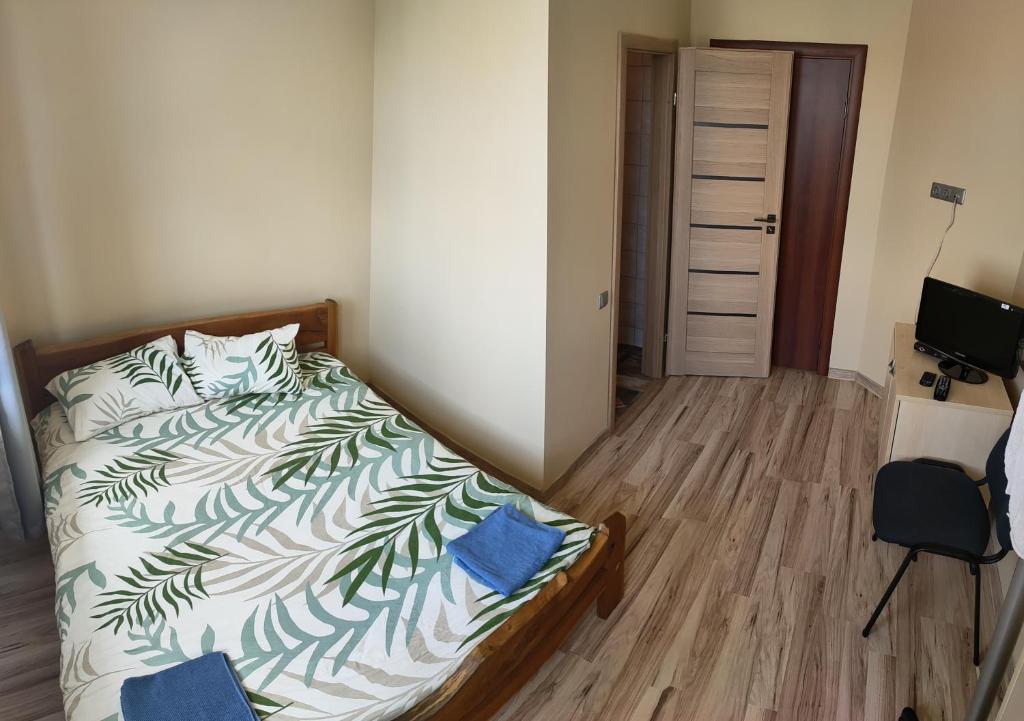 a bedroom with a bed with a green and white comforter at Babilonas in Plungė