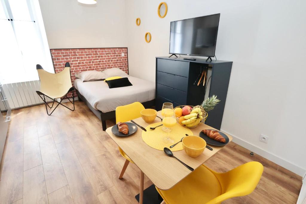 sala de estar con mesa y sillas amarillas en Cosy Street Studio, en Pontivy