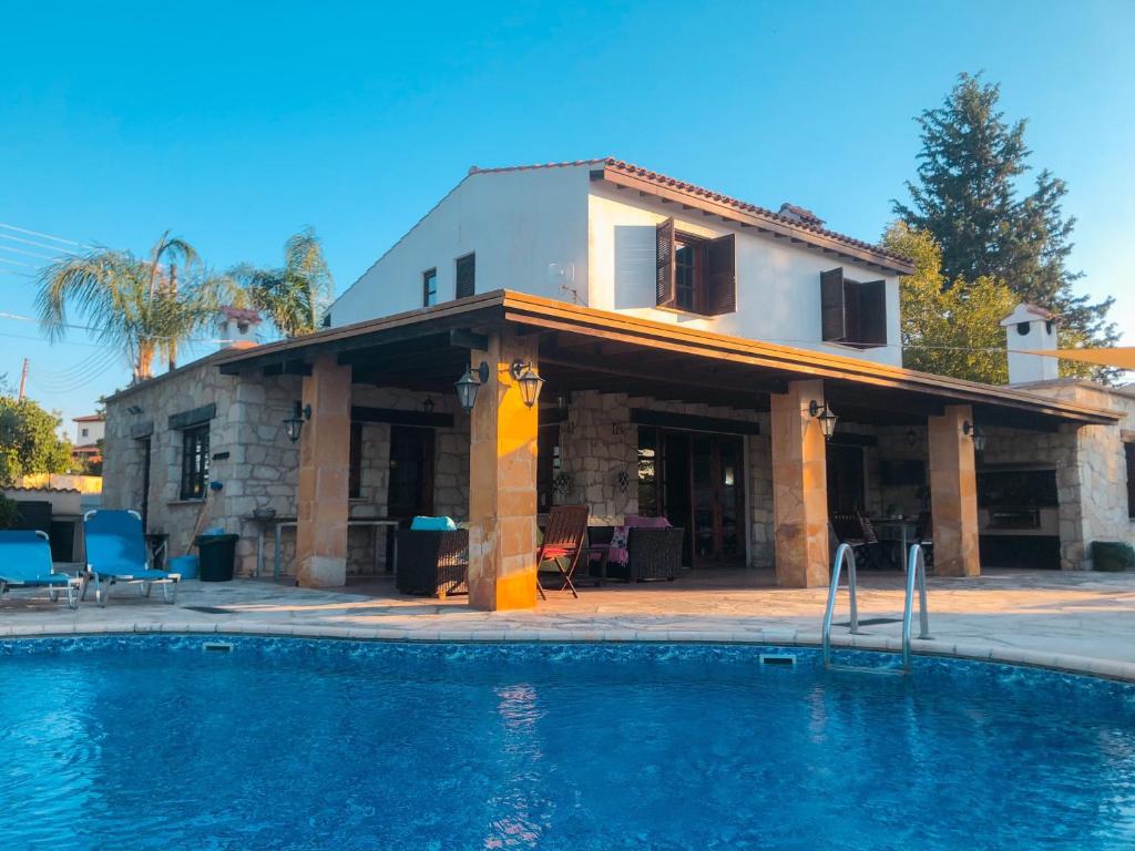 ein Haus mit einem Swimmingpool vor einem Haus in der Unterkunft Koutsini Villa in Pano Akourdalia