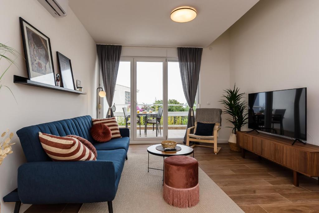 un soggiorno con divano blu e TV di Apartment Maestral a Sutivan (San Giovanni di Brazza)