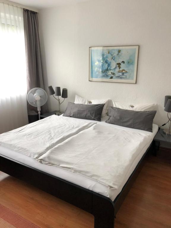 ein Schlafzimmer mit einem großen Bett mit weißer Bettwäsche in der Unterkunft Paolos Seehotel Mardorf in Mardorf