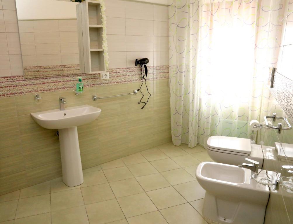 łazienka z umywalką, toaletą i lustrem w obiekcie Marsala d'aMare w mieście Marsala