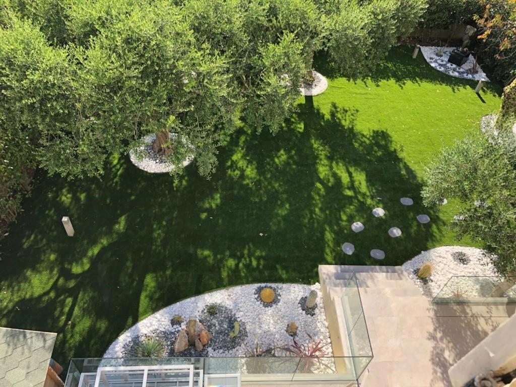 Elle offre une vue sur un jardin avec des arbres et une pelouse. dans l'établissement Beautiful Apartment 2mn walking distance from La Croisette and The Beach, à Cannes
