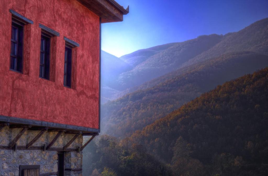 a red building with a view of a valley at Villa Vadola in Arkochórion