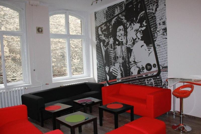 a living room with a black and red couch at La Guitarra Hostel Poznań in Poznań