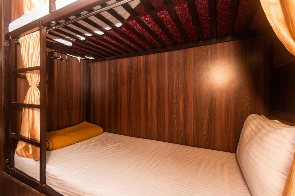 a bed in a room with a wooden bed frame at Almas Dormitory Andheri West in Mumbai