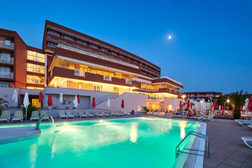a hotel with a swimming pool in front of a building at Hotel Albatros Plava Laguna in Poreč