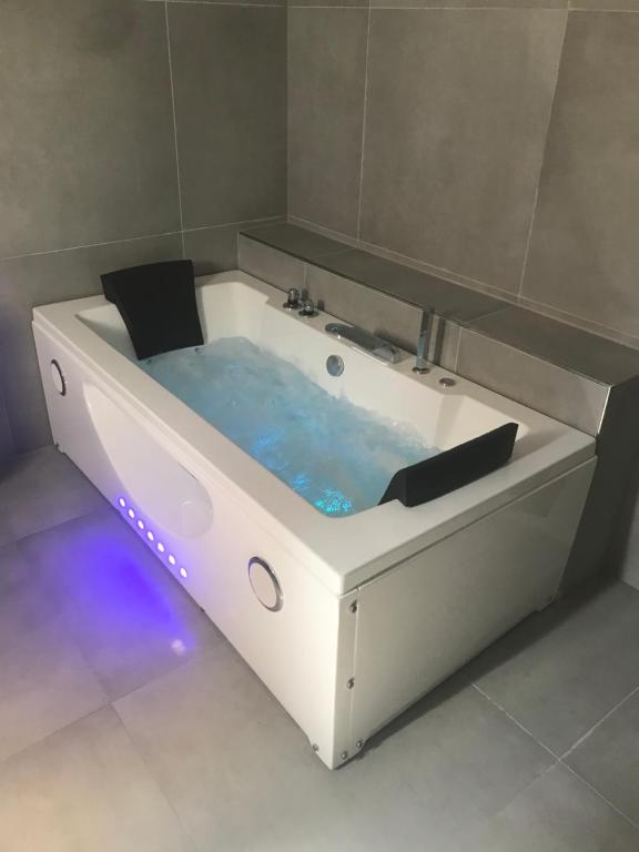 una bañera blanca con agua azul. en Apartmán 3KK 80 m2 s vířivkou a saunou en Jihlava