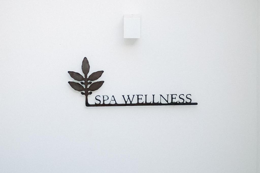 a sign that reads spa wellness with a leaf on it at CORTE LARGO LAURO DIMORE & SPA in Gemini