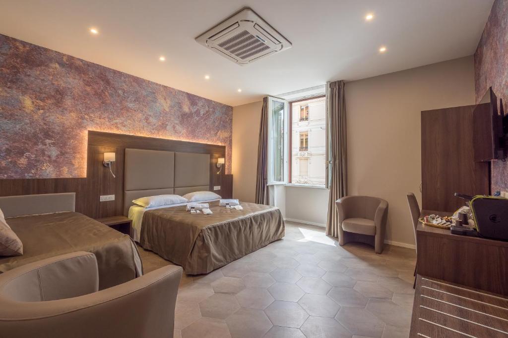 Pokój hotelowy z 2 łóżkami i lustrem w obiekcie Bramble Luxury Suites w Rzymie