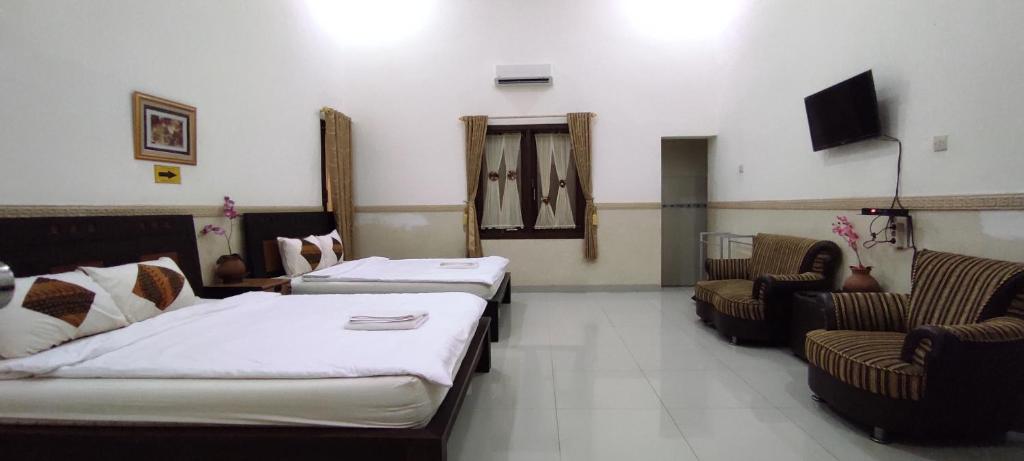 Postel nebo postele na pokoji v ubytování Ndalem Katong Guest House Ponorogo