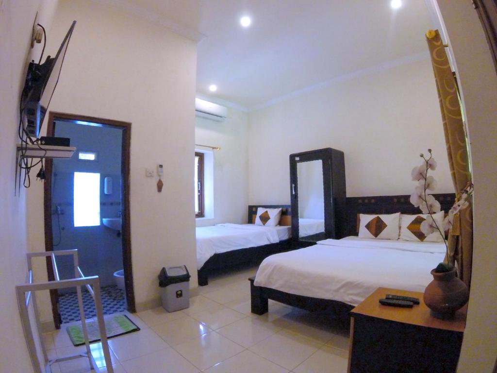 Postel nebo postele na pokoji v ubytování Ndalem Katong Guest House Ponorogo
