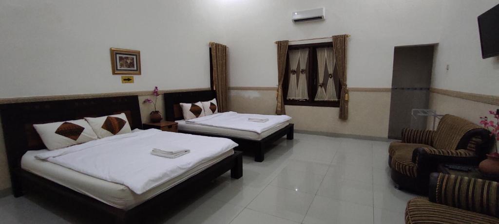 Postel nebo postele na pokoji v ubytování Ndalem Katong Guest House Ponorogo