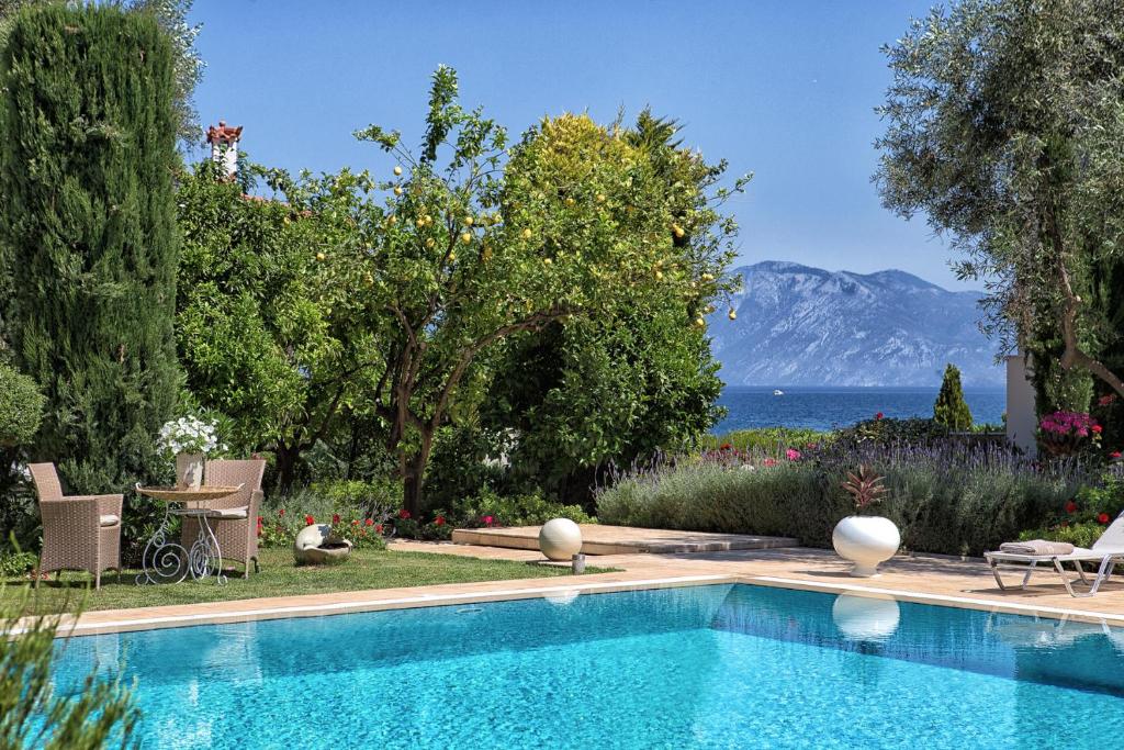 una piscina con vistas al océano y a las montañas en The Marble Resort, en Drosiá