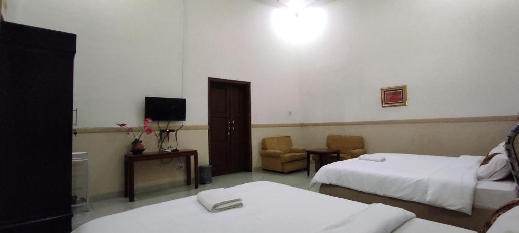 Postel nebo postele na pokoji v ubytování Ndalem Katong Guest House Ponorogo