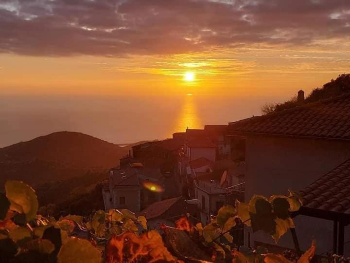 a sunset over a city with the sun in the distance at CarmineHolidayHouse in Pollica