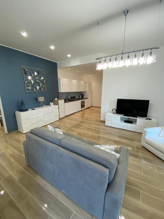 uma sala de estar com um sofá azul e uma televisão em Genoa Lux Apartments with parking em Gênova