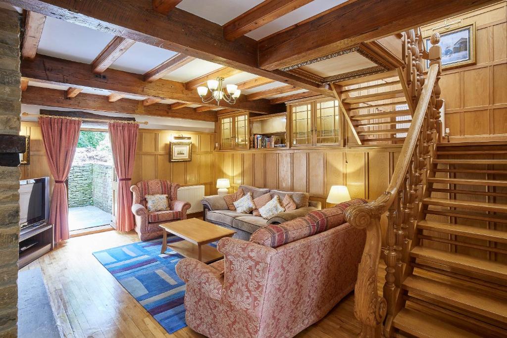 a living room with a couch and a staircase at Host & Stay - The Cottage Barn in Skipton