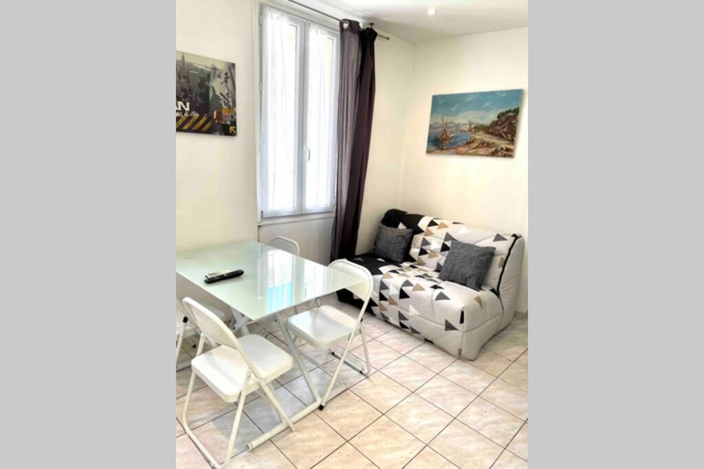 - un salon avec une table en verre et une chaise dans l'établissement Bel Appartement - HYPER CENTRE - 2 pièces, à Cannes