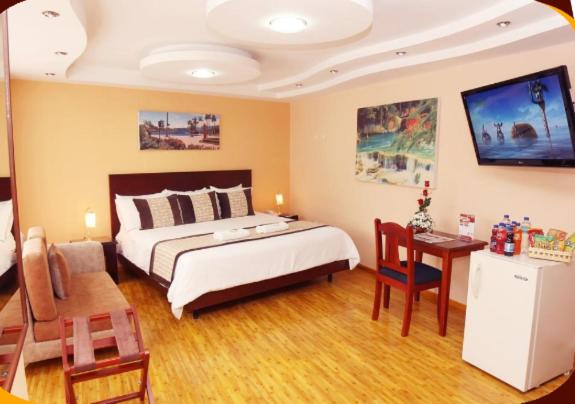 a bedroom with a bed and a table and a desk at Hotel Xilon Resort Pasto in Pasto