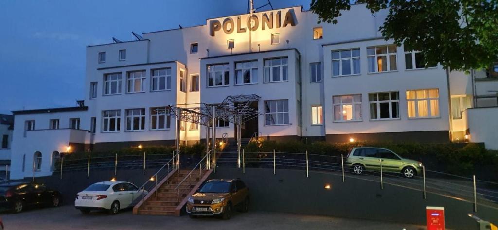 a car parked in front of a building with a clock on it at Polonia in Międzyzdroje