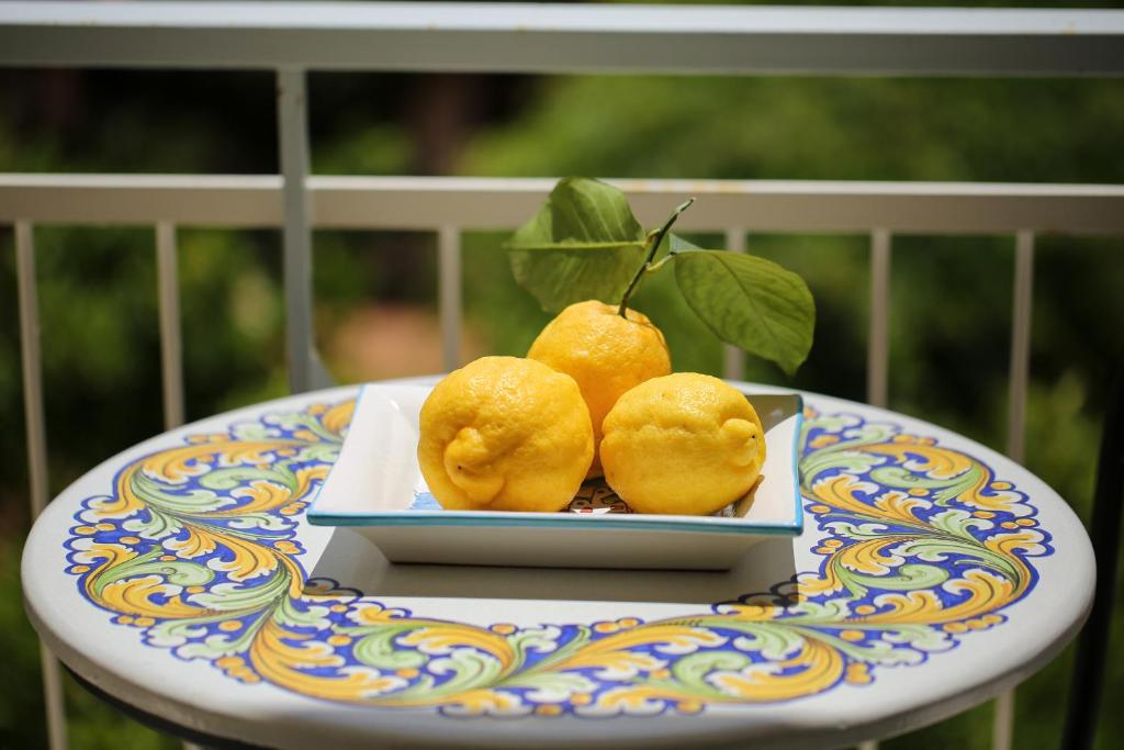 drie citroenen op een bord op een tafel bij SWEET SORRENTO HOLIDAYS in Sorrento