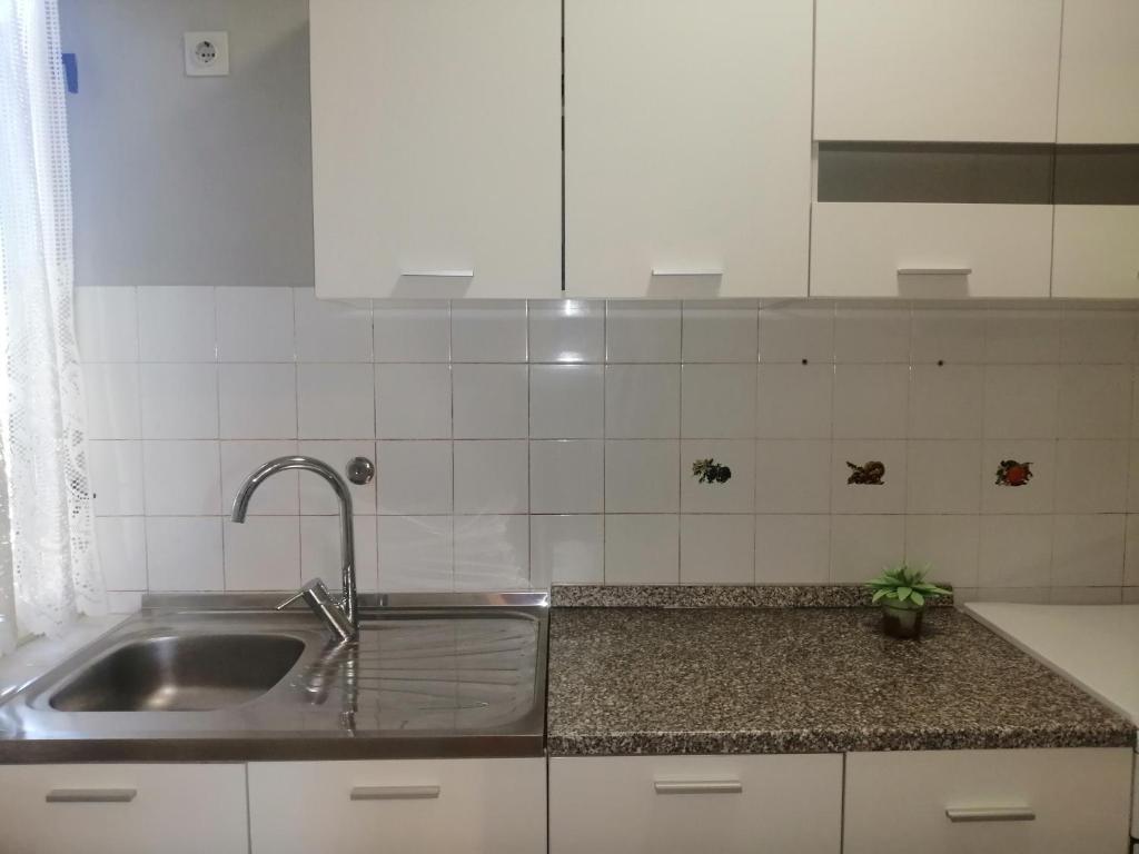 Kuchnia z umywalką ze stali nierdzewnej i białymi szafkami w obiekcie Apartment Vera, 80 m from the sea w mieście Novigrad