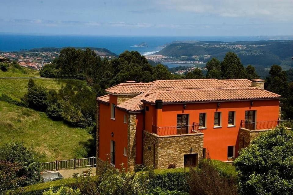 una casa en una colina con el océano en el fondo en Hotel Rural Montesomao, en Somado