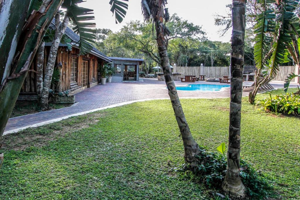 un cortile con una casa e una piscina di Ezulwini Game Lodge a Hluhluwe