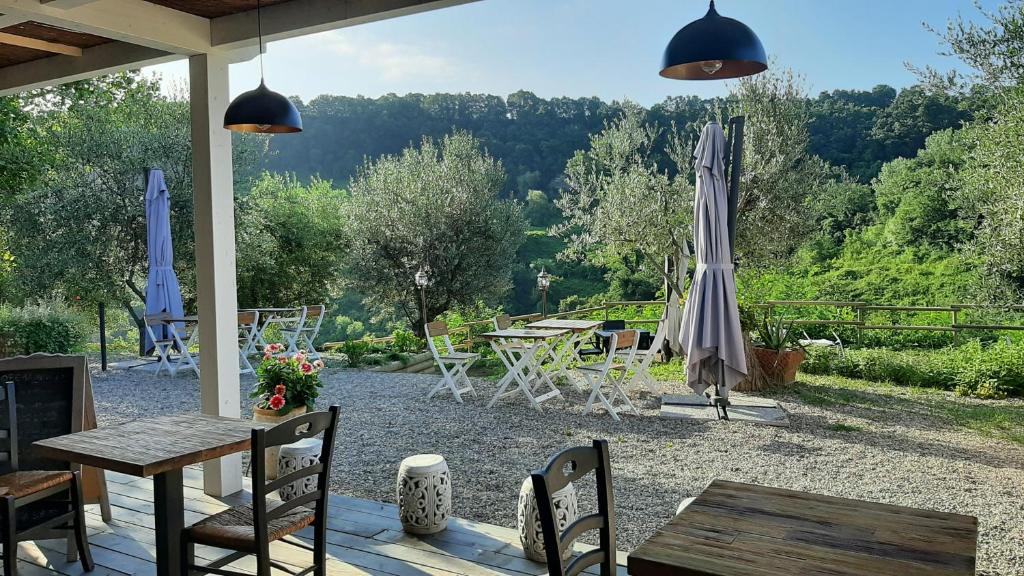 patio z parasolem, stołami i krzesłami w obiekcie Bio Agriturismo Valle dei Calanchi w mieście Castiglione in Teverina